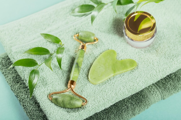 Massage roller for the face with two heads and gua sha scraper of green stone