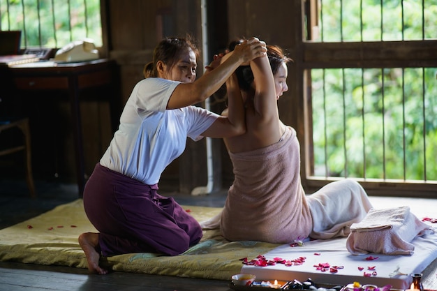 사무실 증후군의 마사지 및 스파 편안한 치료 마사지를 하는 전통적인 태국 마사지 스타일 Asain 여성 안마사는 일에 지친 사무실 여성을 위해 허리 통증 팔 통증과 스트레스를 치료합니다.