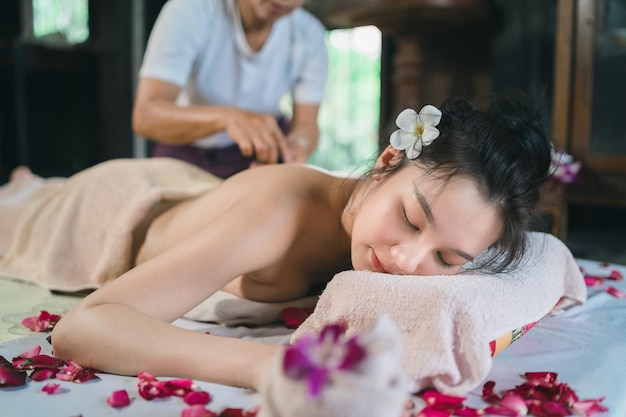 Massage and spa relaxing treatment of office syndrome using hot stone traditional thai massage style Asain female masseuse doing massage treat back pain arm pain stress for woman tired from work