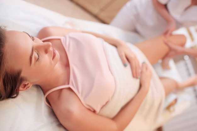 Massage therapist makes a foot massage for a pregnant woman