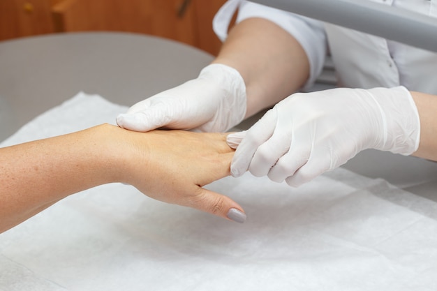 Massage therapist massaging hands of a woman in a beauty salon