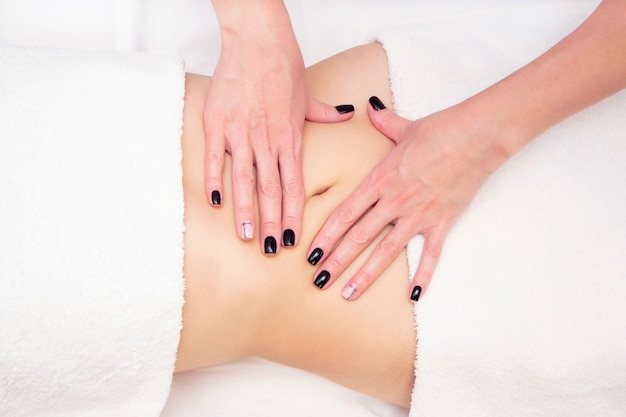 Massage Therapist Massaging a Womens Stomach. Massage and body care. Spa body massage woman hands treatment.