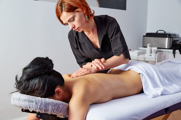 massage in woman back with physiotherapist