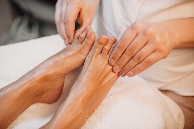 Massageprocedure voor voeten en tenen uitgevoerd door een professionele spa-medewerker in de salon