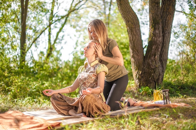 Massagespecialist masseert een meisje grondig in de rustige buitenlucht.