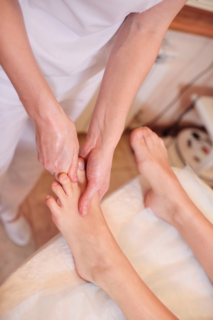 Foto massagetherapeut die voetmassage doet