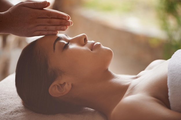 Massaging the body and mind Shot of a beautiful young woman getting a head massage at a spa