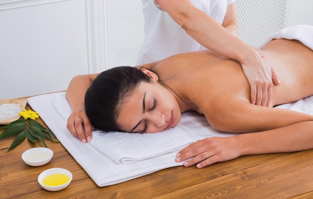 Massagist makes body massage in spa wellness center