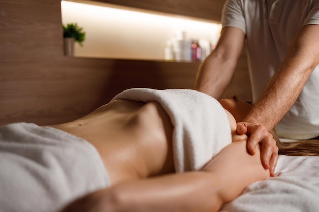 Masseur die de schouders van de vrouw masseert in de spa salon