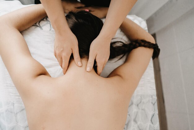 Masseur doet een voetmassage met kaarsen op de achtergrond