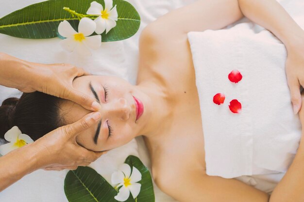 Masseur doing massage the head of an Asian woman