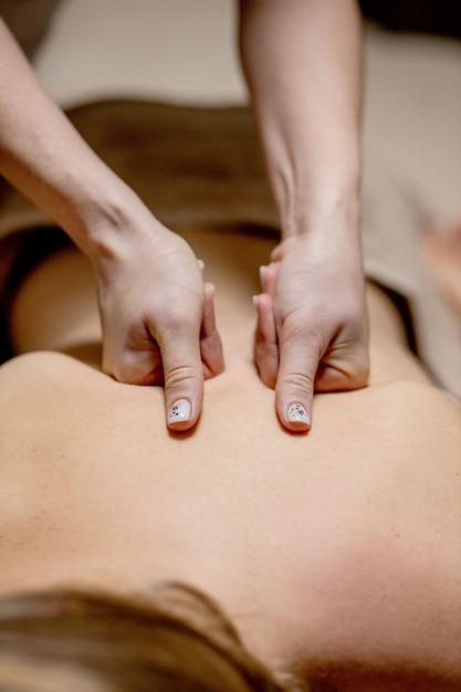 Masseur doing massage on man body in the spa salon. Beauty treatment concept.