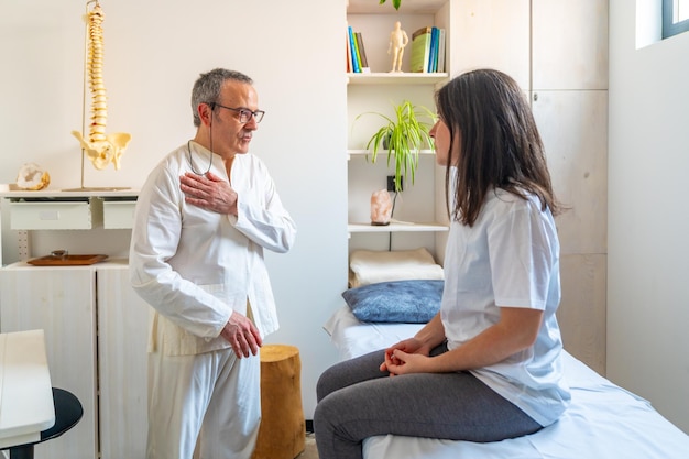 Masseur en patiënt praten in een qi gong massagecliniek