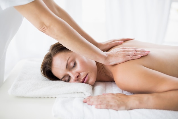 Masseur giving back massage to woman