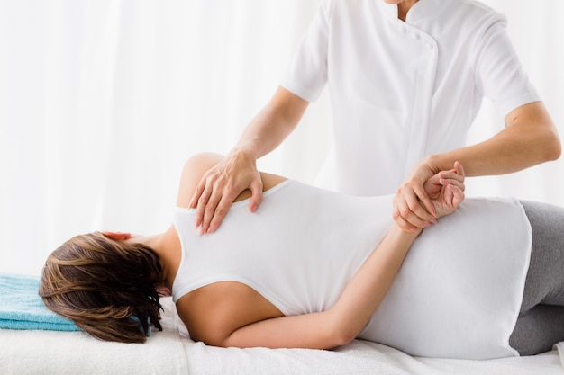 Masseur giving massage to woman