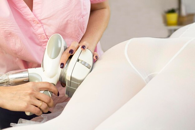 The masseur is preparing to do a hardware anti-cellulite massage in a beauty salon. lpg massage