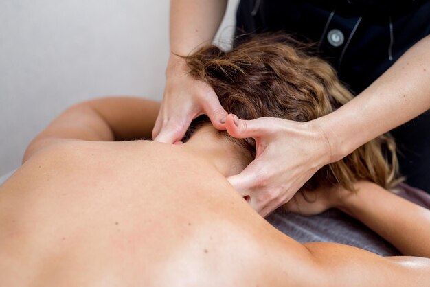 Masseur makes neck massage