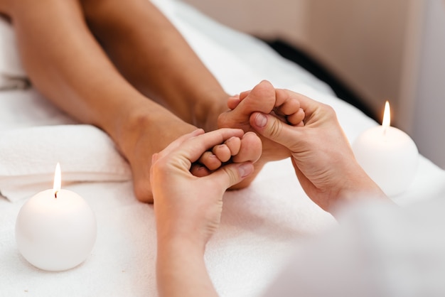 Photo masseur making feet massage in spa salon.