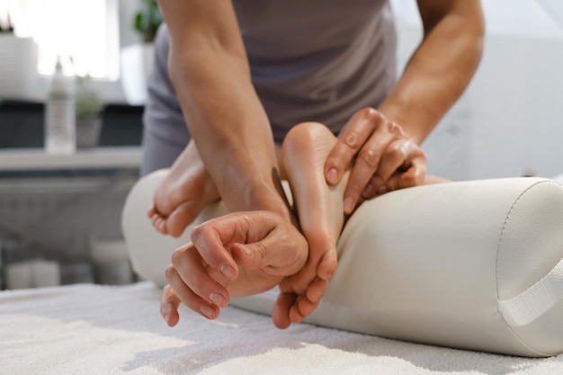 Masseur making medical massage to child foot and body