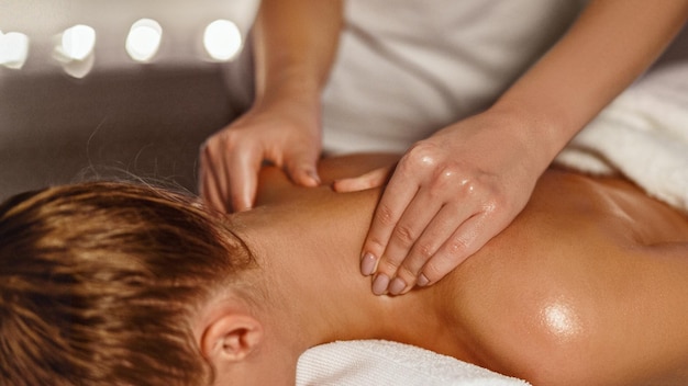 Photo masseur making therapeutic neck massage for girl