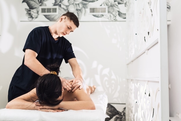 Masseur man doing back massage.