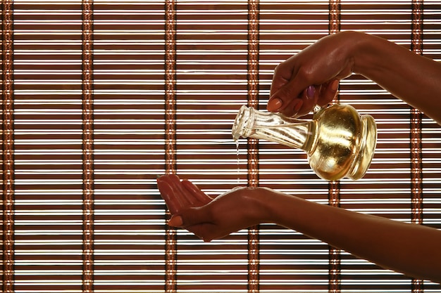 Masseur pours fragrance oil on the palm