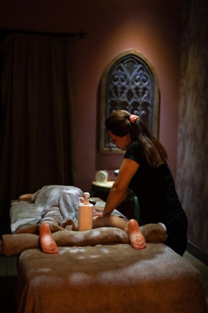 A masseuse gives a massage in a dark room