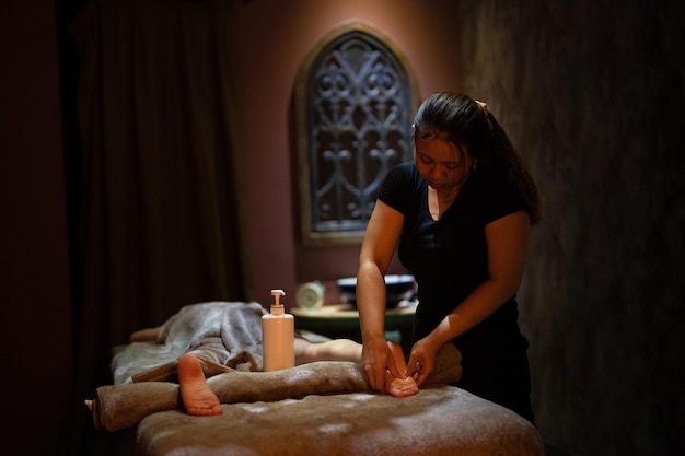 A masseuse gives a massage in a dark room