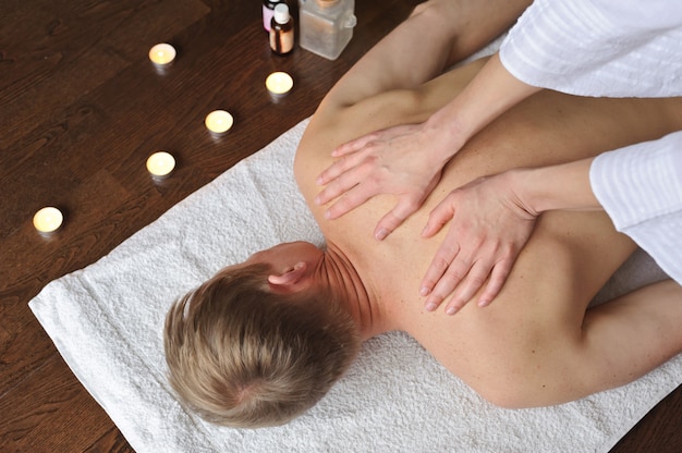 A masseuse is doing a shoulder massage to a man