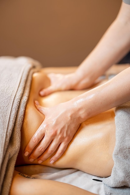 Masseuse performs professional abdominal massage for a woman