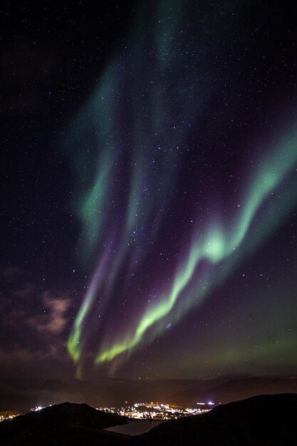 Massief groen Aurora Borealis Noorderlicht schijnt over het meer en Nuuk stad Groenland