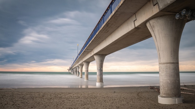 massieve betonnen pier die naar de horizon leidt, omringd door de oceaan