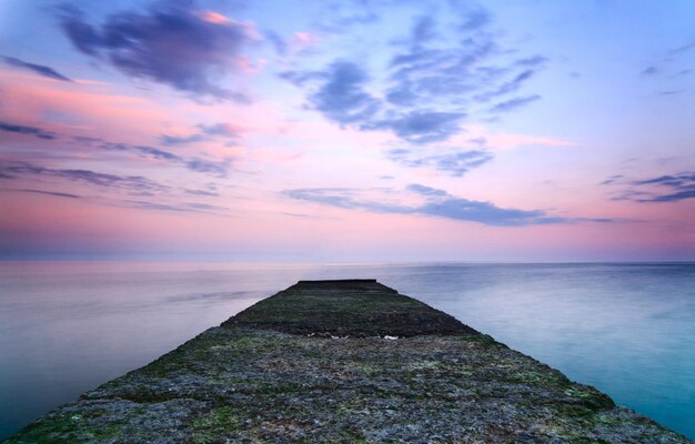 A massive breakwater crashing into the depths of the sea and\
protecting the seashore from the elements of the sea wonderful\
sunset on the sea pure and wonderful nature of crimea ukraine