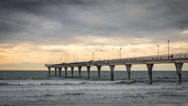 日没時に海に囲まれた地平線につながる巨大なコンクリートの桟橋christchurchnewzealand