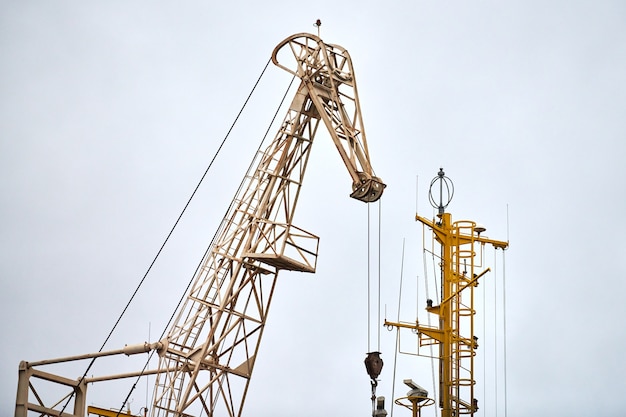 Massive harbor crane in port. Heavy load dockside crane in seaport, cargo container yard, container ship terminal. Business and commerce, logistic