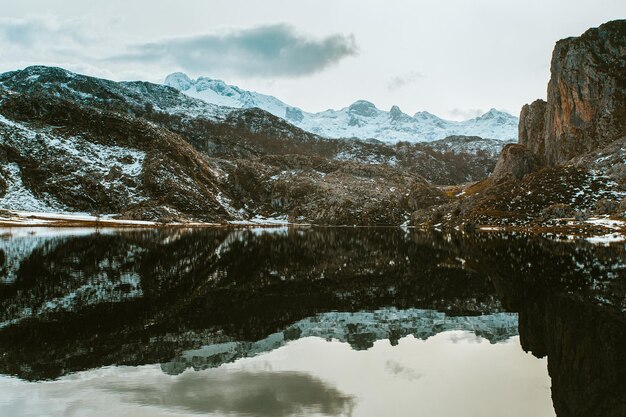 Photo massive mountain reflecting on the frozen lake in the lakes of covadonga