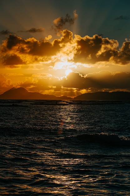 A massive sunset between the clouds with some islands over the ocean