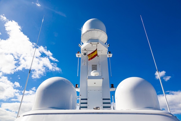 The mast of a modern motor yacht with navigational radars and satellite equipment on top