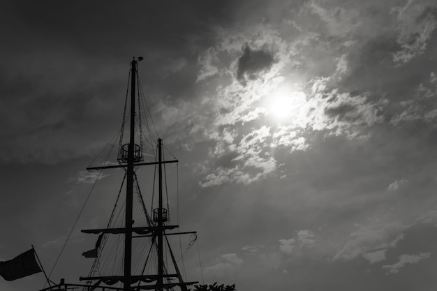 Mast of the ship against the background of the cloudy sky black and white
