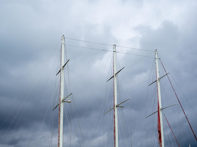 masten van een schip zonder zeilen De zeilen zijn neer Bewolkte hemel Schip