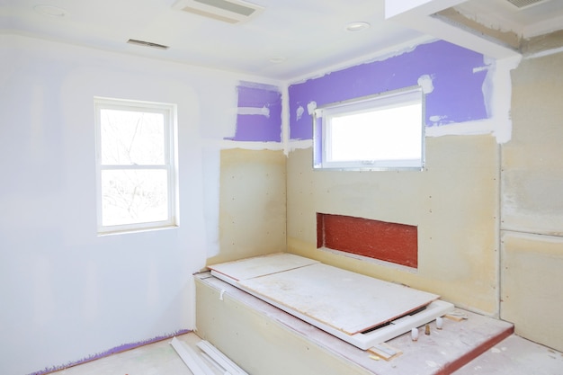 Master bathroom with new under construction bathroom interior drywall ready for tile in new luxury home