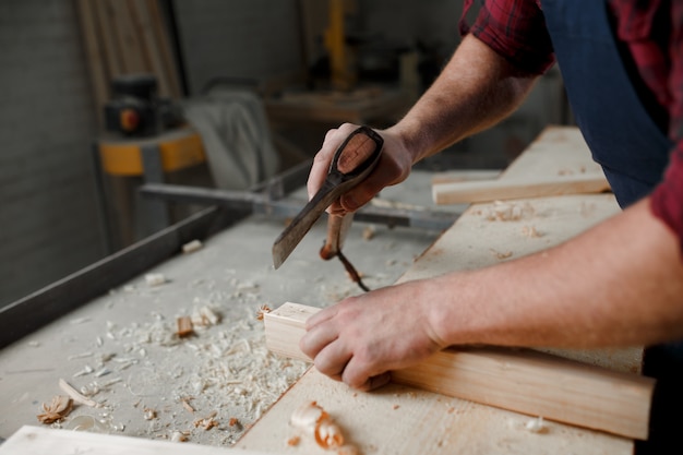 Master carpenter in shirt and apron in the workshop