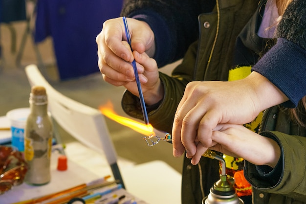 Master class on making decorative toys from glass, the teacher shows how to melt and make