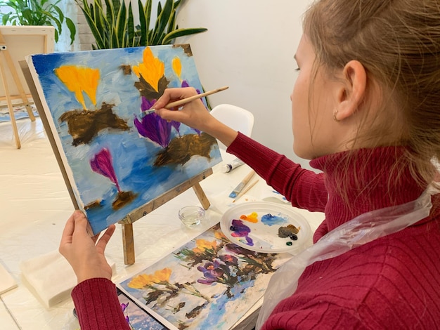 Master class in oil painting on canvas Young artist girl draws with paints on canvas in the studio