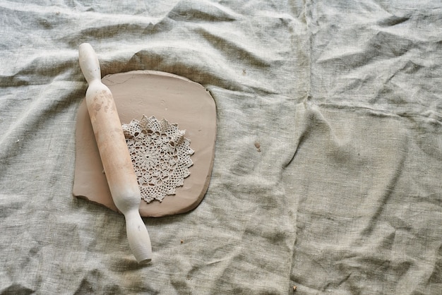 Master craftsman rolls the clay on the table, transfers the napkin pattern to the clay mass