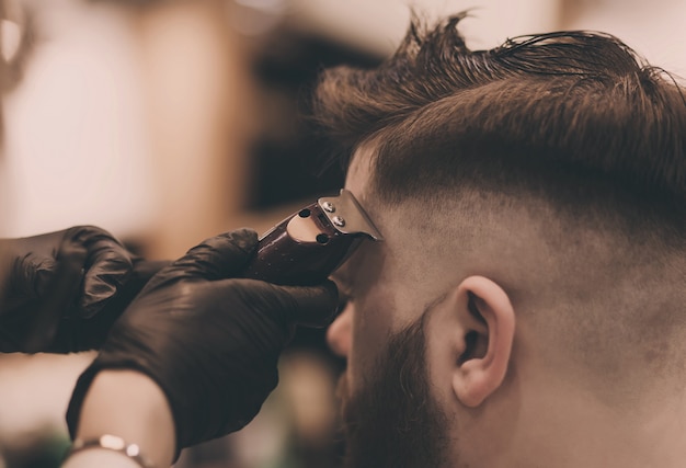 Master cuts a bearded man in a barbershop