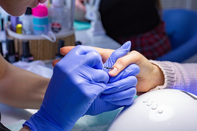 The master does a manicure in the salon