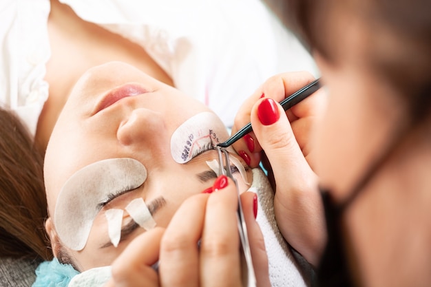 Photo the master glues bundles of eyelashes using black superglue