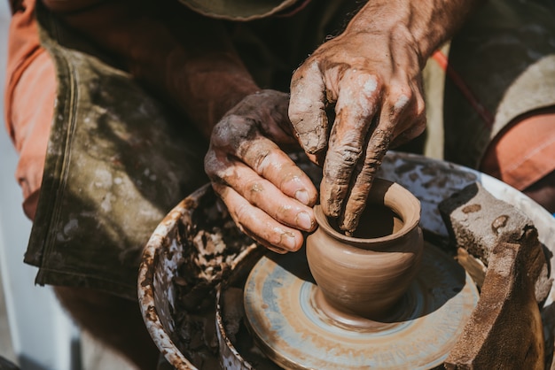 Master handmakes a pot of clay