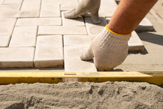 The master  lays paving stones in layers